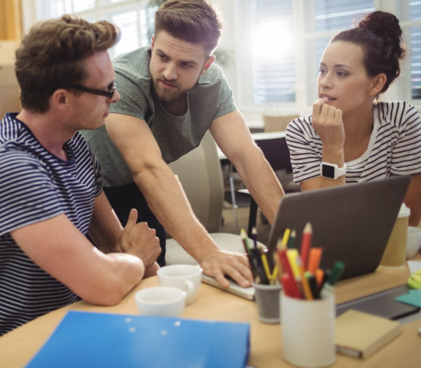 Grupo de fundadores mexicanos analizando ideas de negocio y documentos legales en oficina moderna.